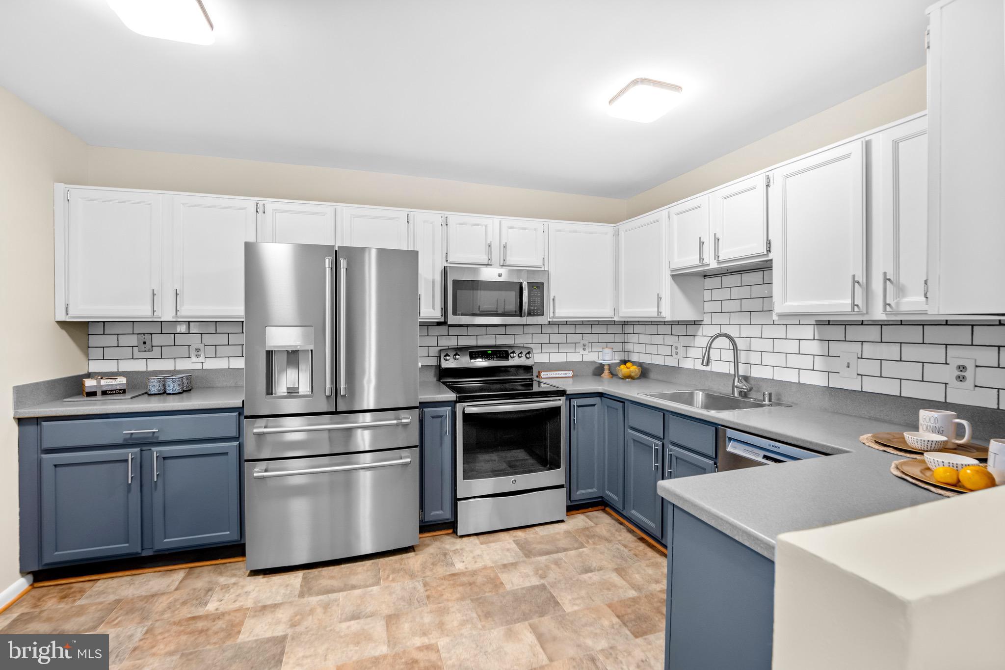 7512 Rolling Road Springfield, VA 22153 - Photo 8 of 32 a kitchen with granite countertop a sink stainless steel appliances and cabinets
