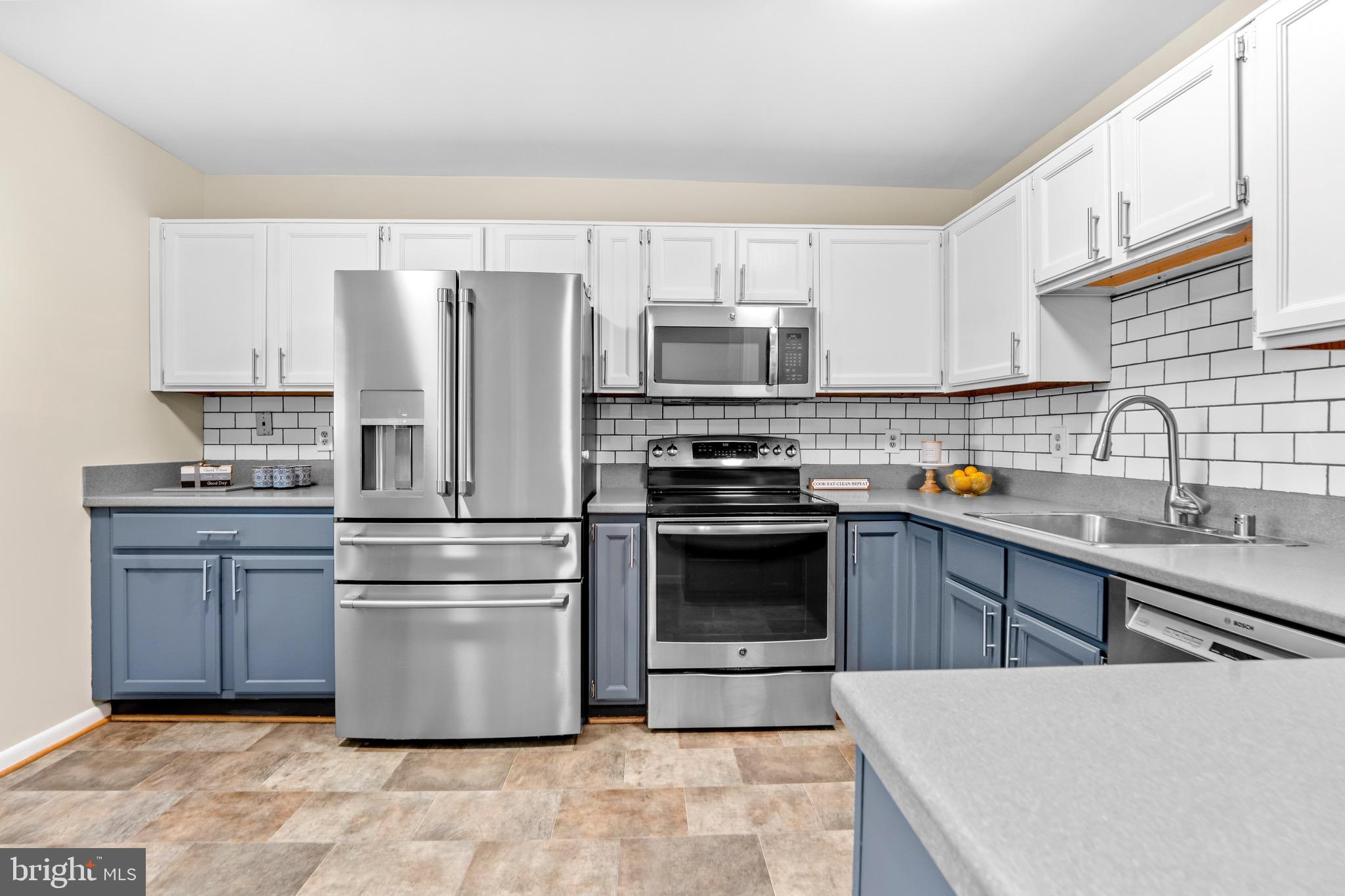 7512 Rolling Road Springfield, VA 22153 - Photo 9 of 32 a kitchen with kitchen island a sink stainless steel appliances and cabinets