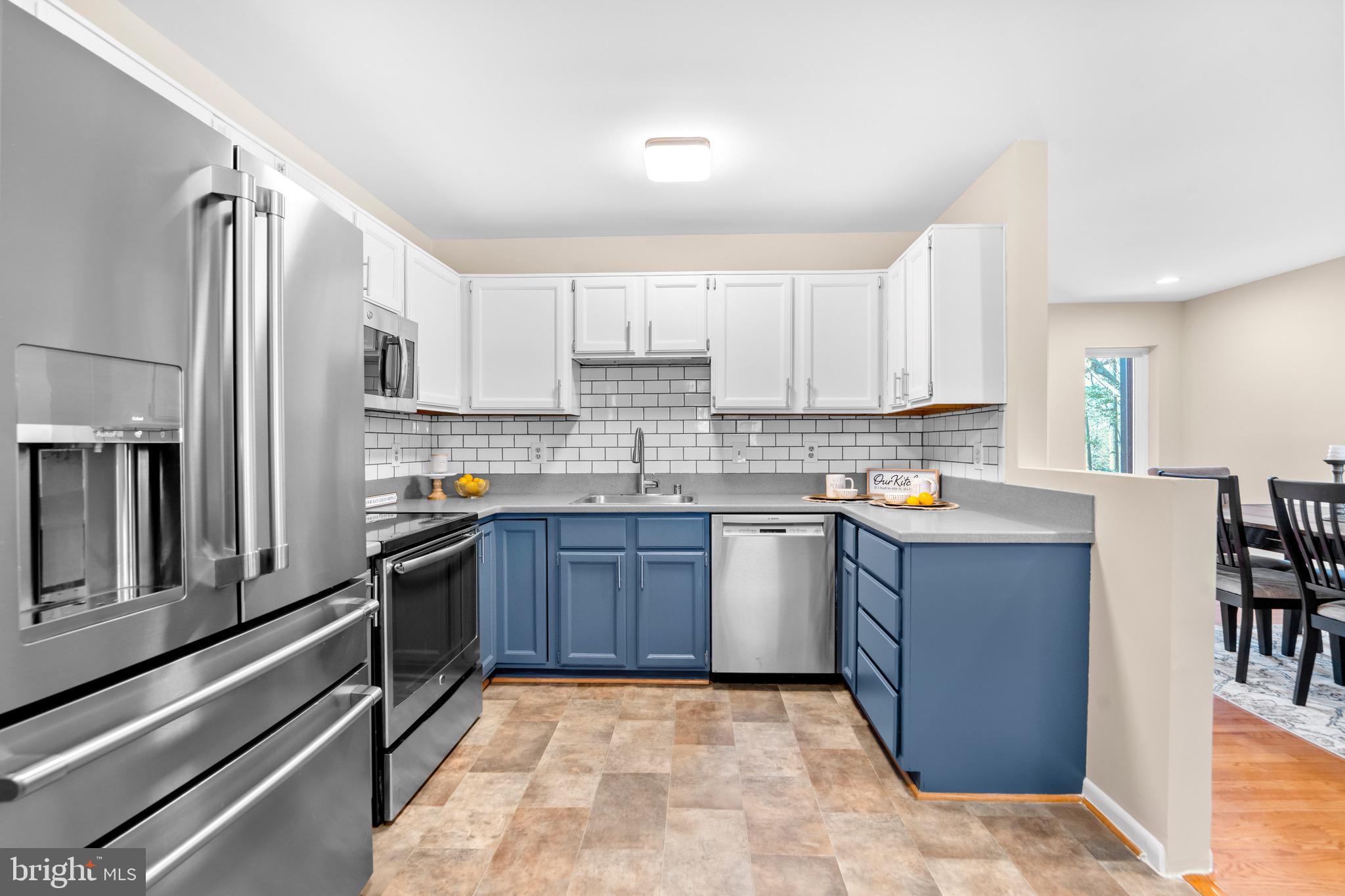 7512 Rolling Road Springfield, VA 22153 - Photo 10 of 32 a kitchen with stainless steel appliances granite countertop a refrigerator sink and stove