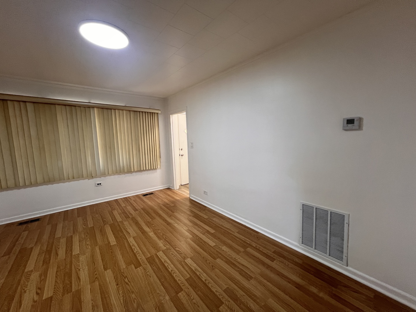 3741 South Union Avenue Chicago, IL 60609 - Photo 3 of 26 a view of an empty room with wooden floor and a window