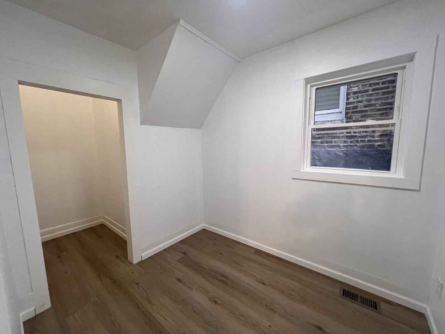 3741 South Union Avenue Chicago, IL 60609 - Photo 10 of 26 a view of an empty room with wooden floor and a window