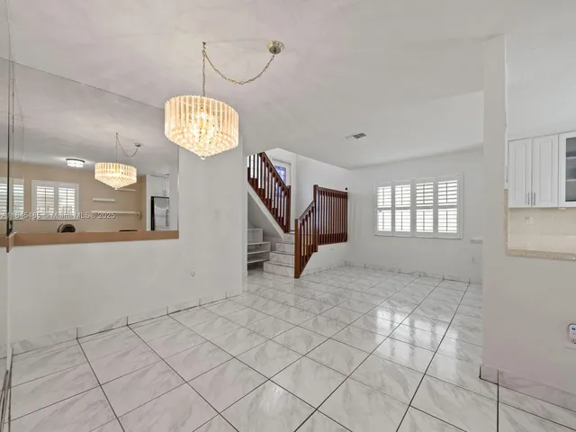 a kitchen with white cabinets and refrigerator