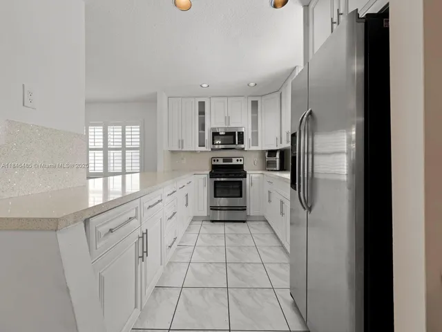 a kitchen with white cabinets and a stove top oven