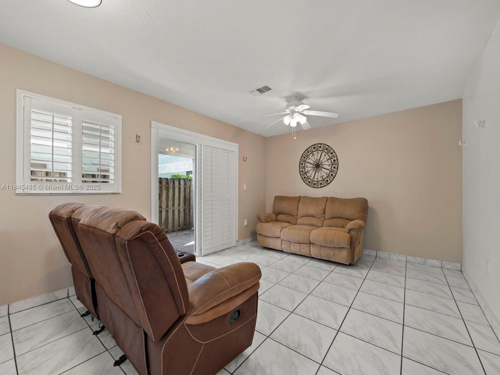 331 Northwest 101st Terrace Pembroke Pines, FL 33026 - Photo 19 of 42 a living room with furniture a clock and a window