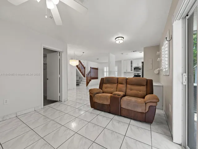 an empty room with a ceiling fan and carpet