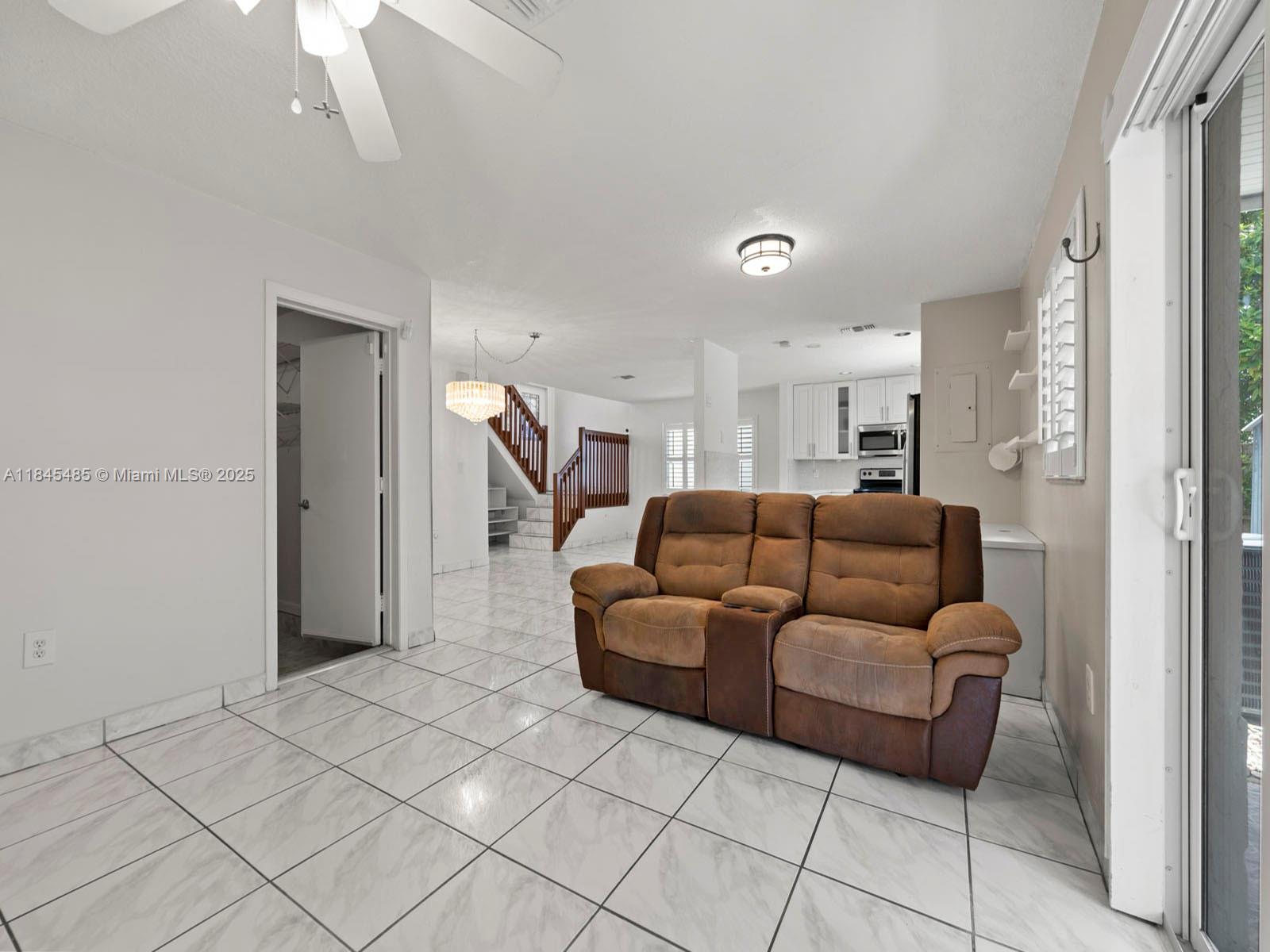 331 Northwest 101st Terrace Pembroke Pines, FL 33026 - Photo 20 of 42 a living room with furniture and a chandelier