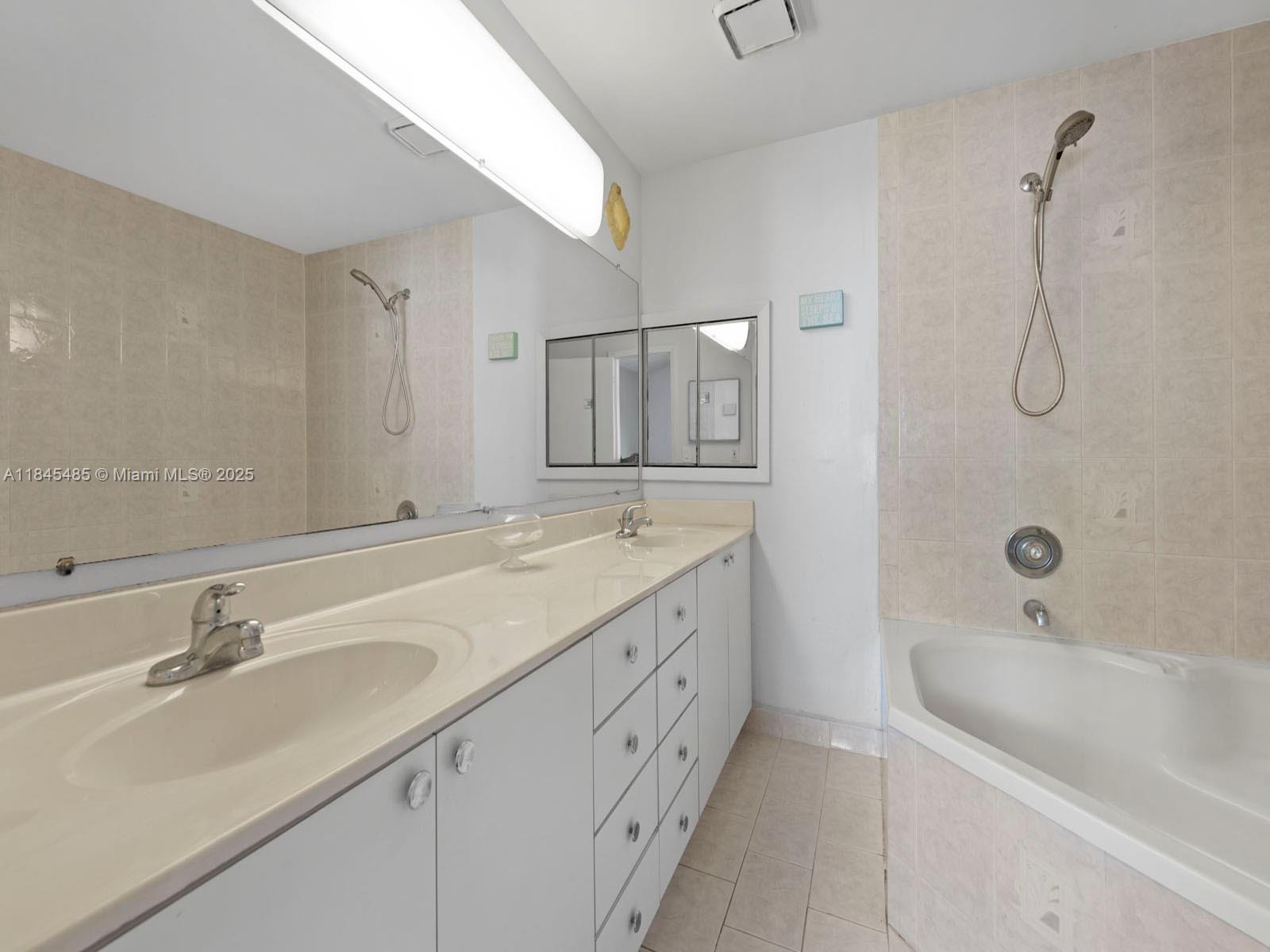 331 Northwest 101st Terrace Pembroke Pines, FL 33026 - Photo 33 of 42 a bathroom with a double vanity sink a mirror and a bathtub