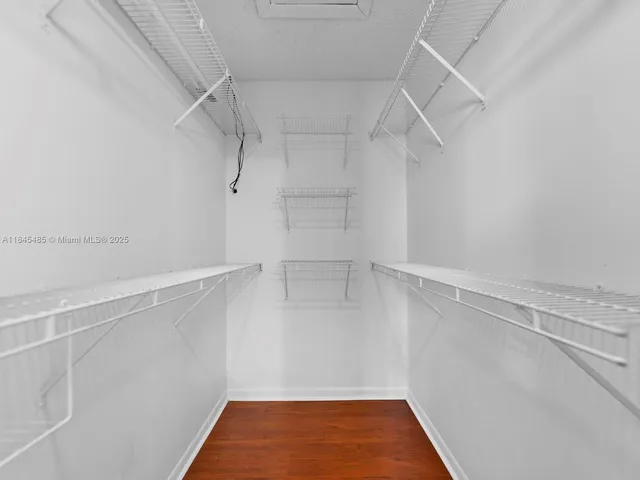 an empty room with wooden floor and window