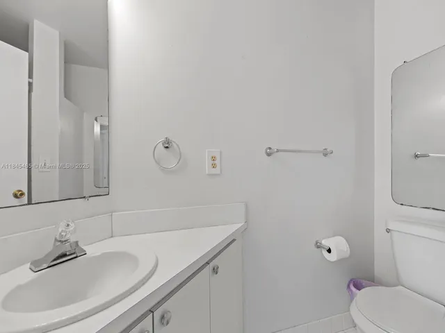 a bathroom with a granite countertop sink a toilet and shower
