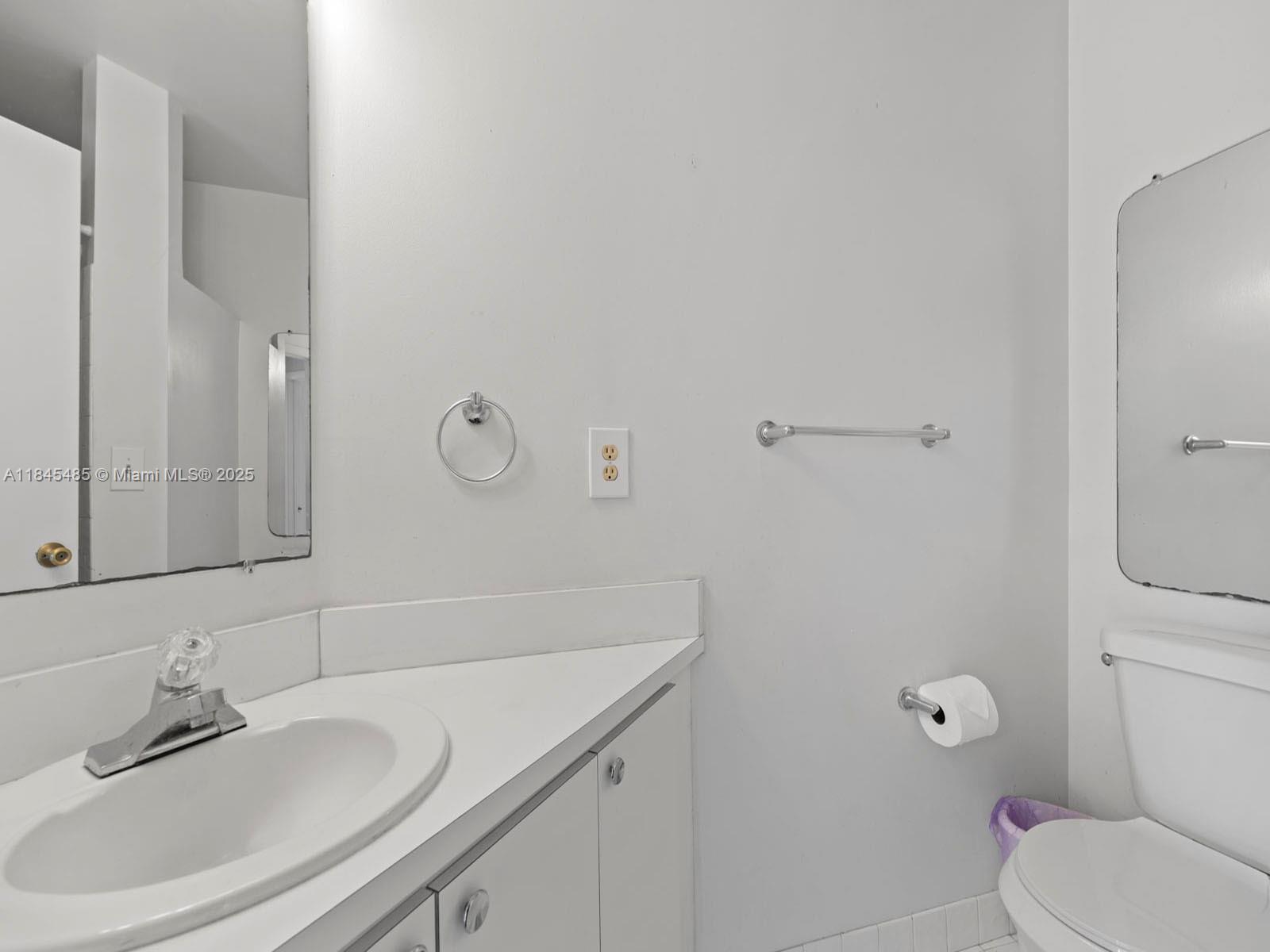 331 Northwest 101st Terrace Pembroke Pines, FL 33026 - Photo 37 of 42 a bathroom with a granite countertop sink a toilet and a mirror