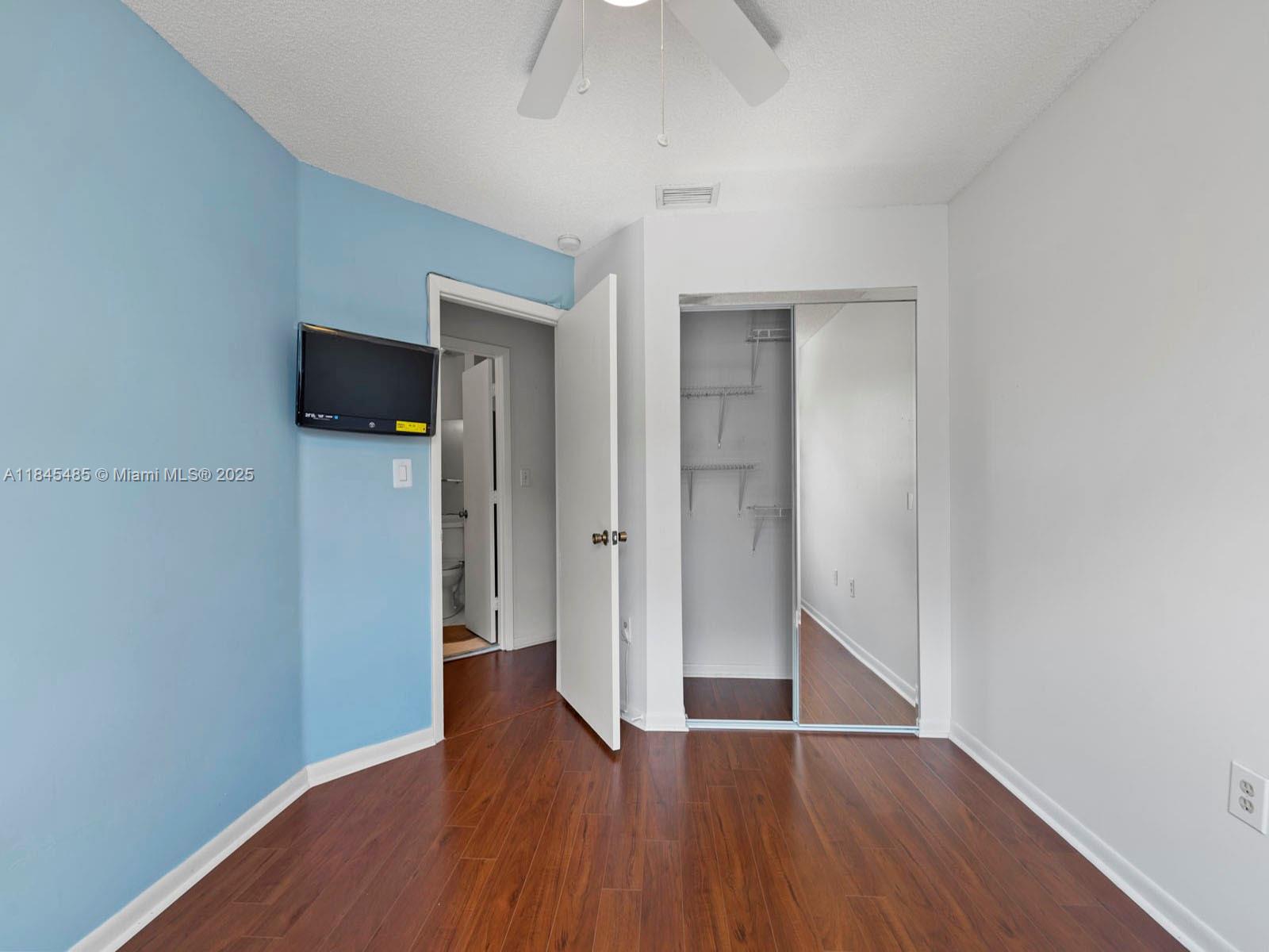 331 Northwest 101st Terrace Pembroke Pines, FL 33026 - Photo 40 of 42 an empty room with wooden floor and ceiling fan