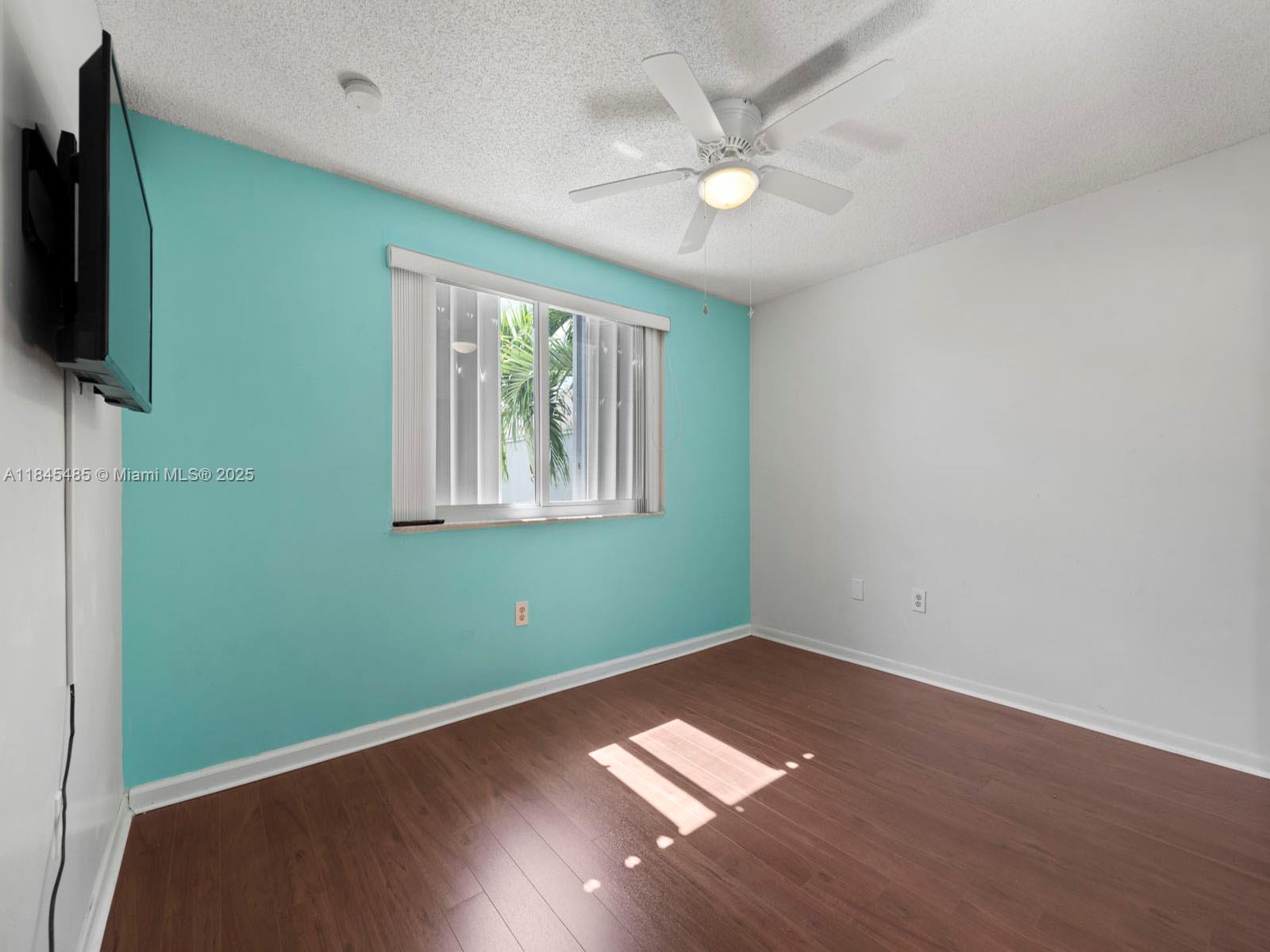 331 Northwest 101st Terrace Pembroke Pines, FL 33026 - Photo 41 of 42 an empty room with wooden floor fan and windows