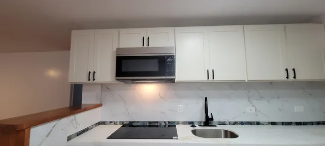 a kitchen with a stove and white cabinets