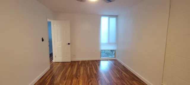 a view of a room with wooden floor and window