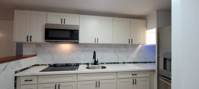 a kitchen with white cabinets and a stove top oven