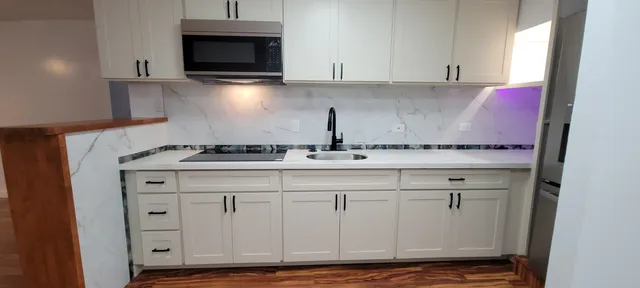 a kitchen with granite countertop a sink and a stove