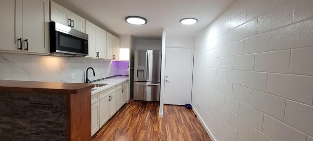 a kitchen with a sink a microwave and cabinets