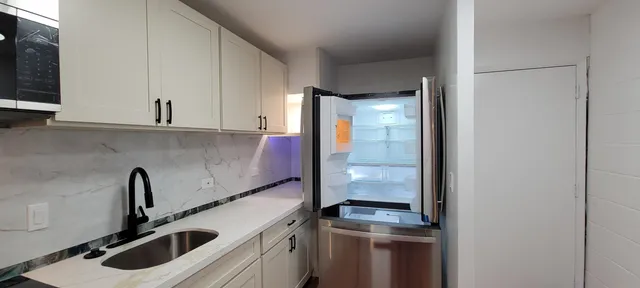 a kitchen with a sink and a refrigerator