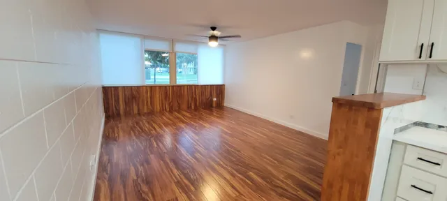 a view of wooden floor and a chandelier fan in a room