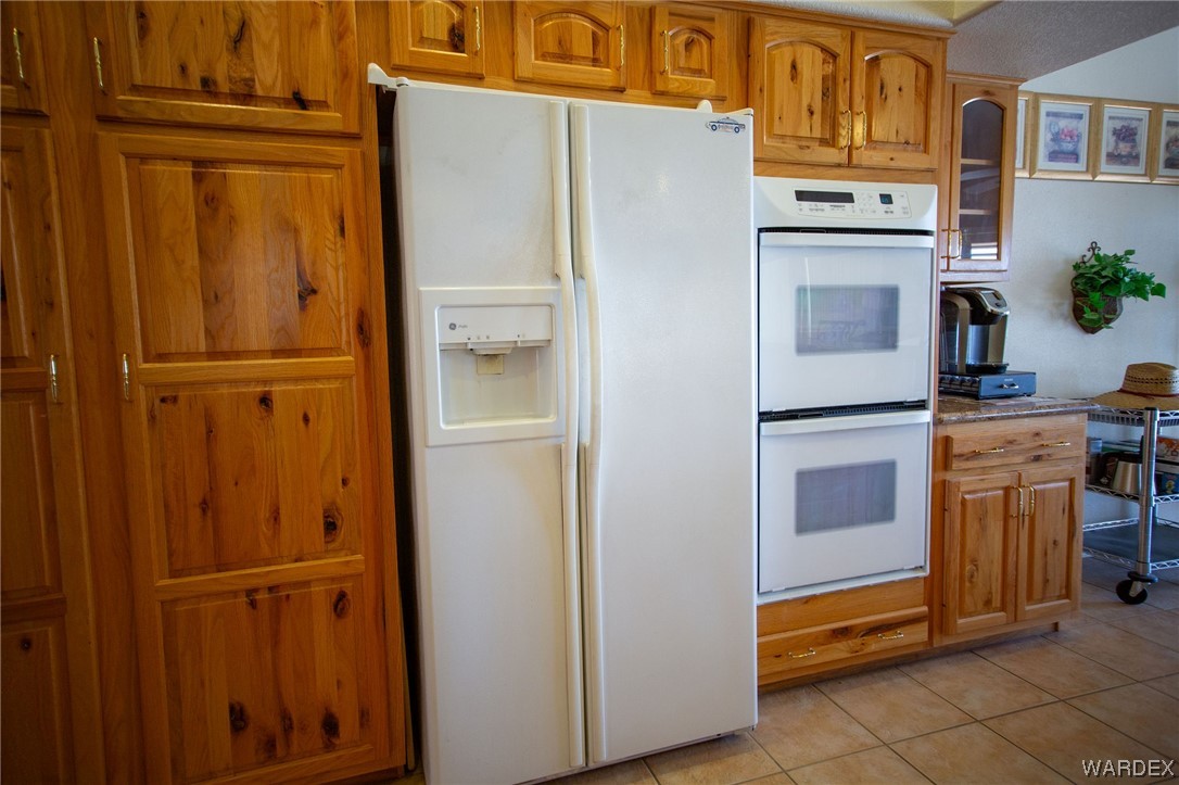 2660 Pegasus Ranch Road Bullhead City, AZ 86429 - Photo 17 of 57 a white refrigerator freezer and a stove sitting inside of a kitchen