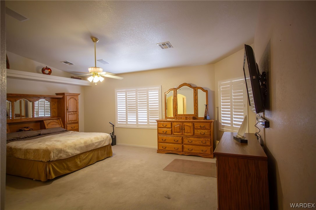2660 Pegasus Ranch Road Bullhead City, AZ 86429 - Photo 21 of 57 a bedroom with a bed and dresser with mirror