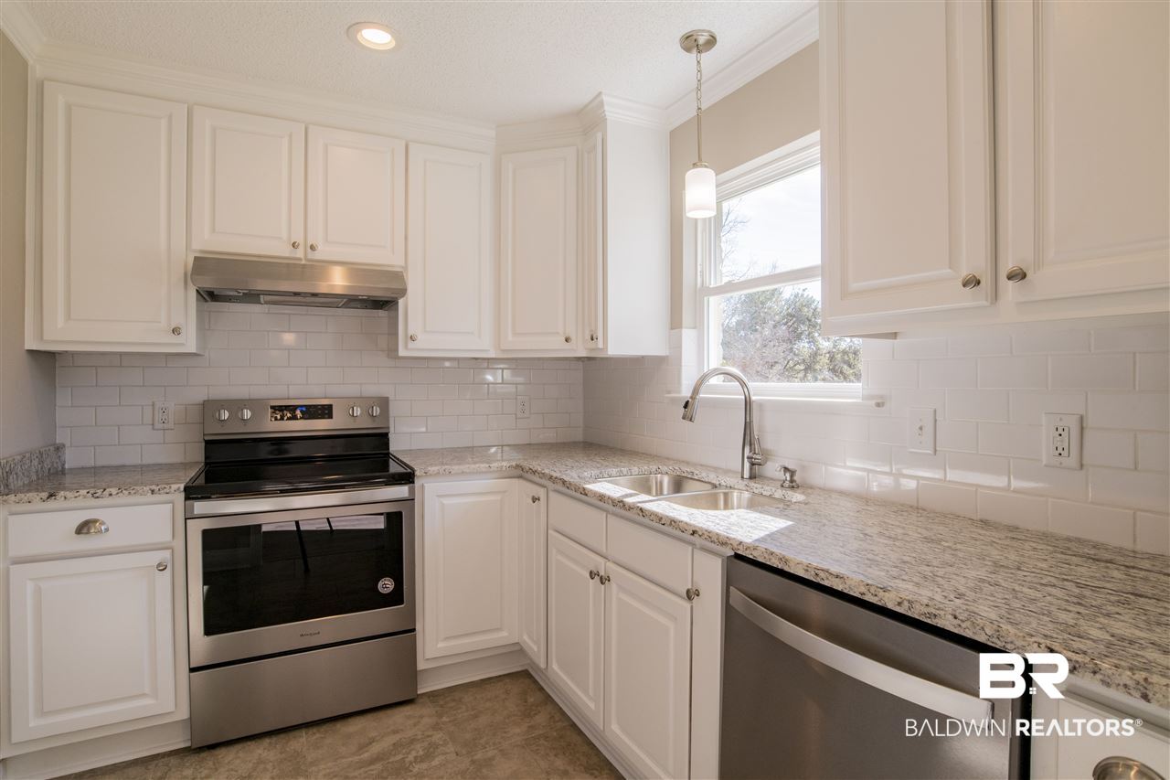 9141 Semmes Court Semmes, AL 36575 - Photo 12 of 28 Granite countertops and subway tile backsplash.