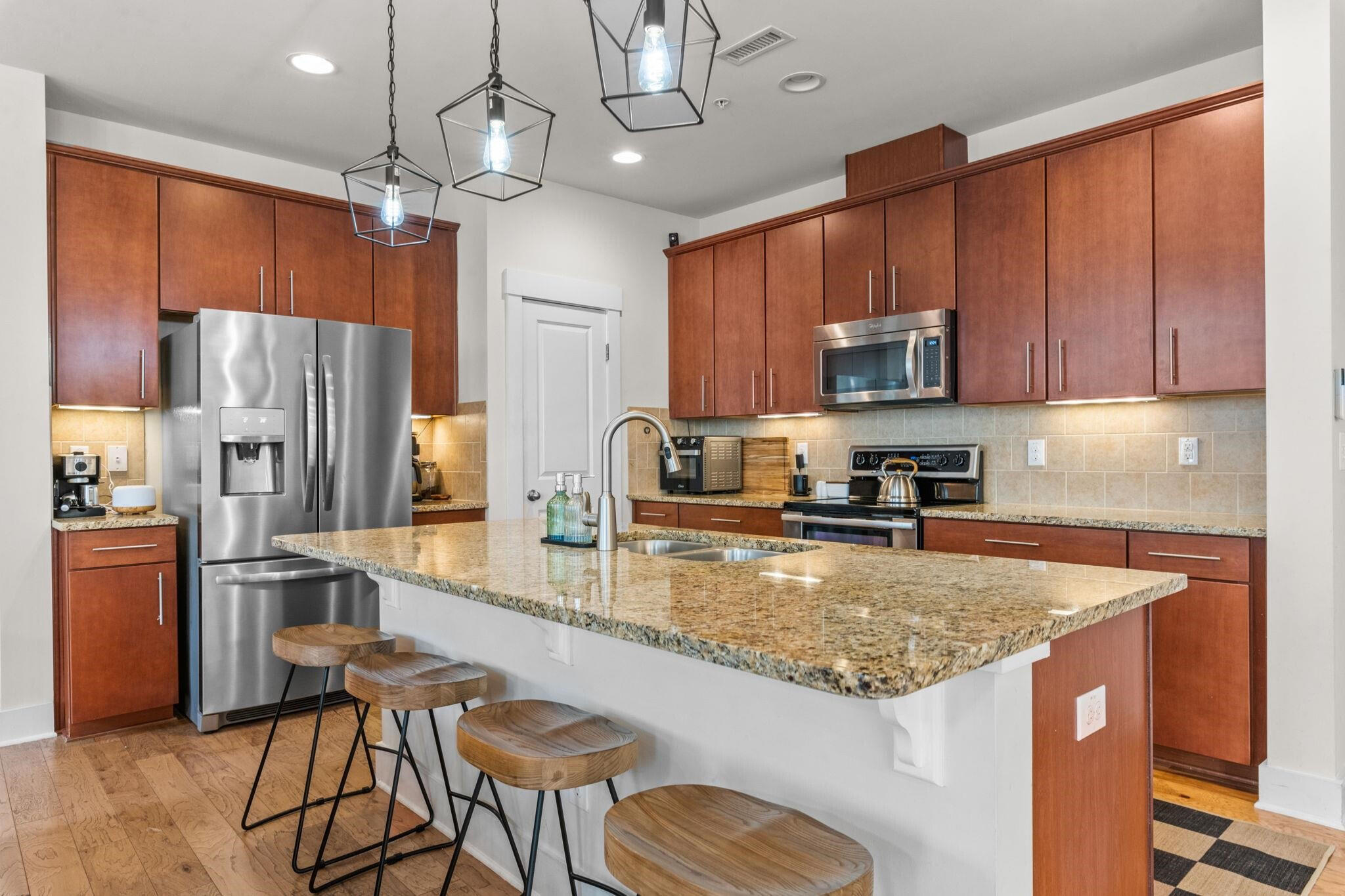 9304 Sevillanos Walk Raleigh, NC 27617 - Photo 13 of 41 a kitchen with stainless steel appliances granite countertop a refrigerator a stove top oven a sink dishwasher and wooden cabinets