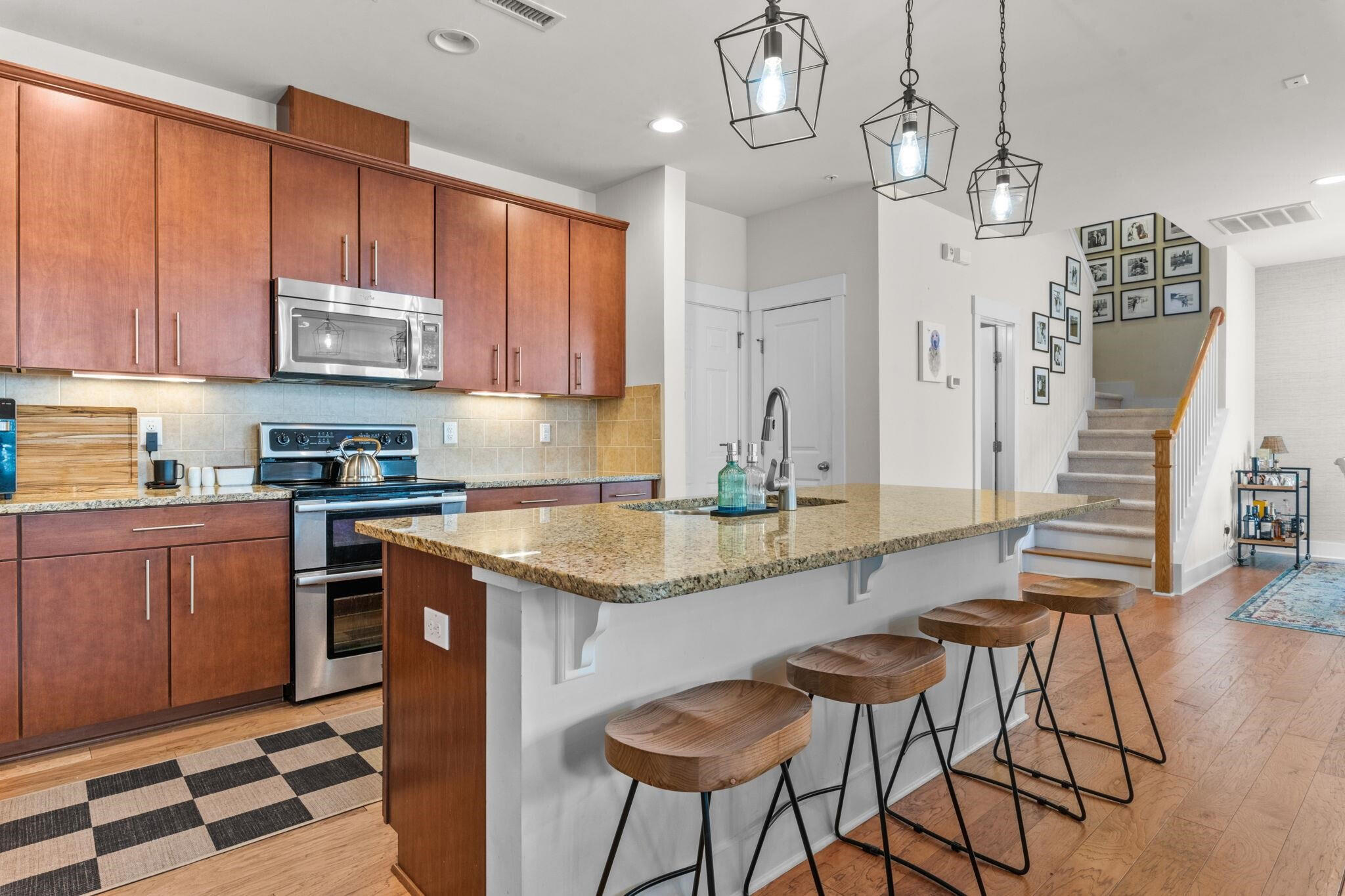 9304 Sevillanos Walk Raleigh, NC 27617 - Photo 14 of 41 a kitchen with stainless steel appliances granite countertop a stove a sink dishwasher and cabinets with wooden floor