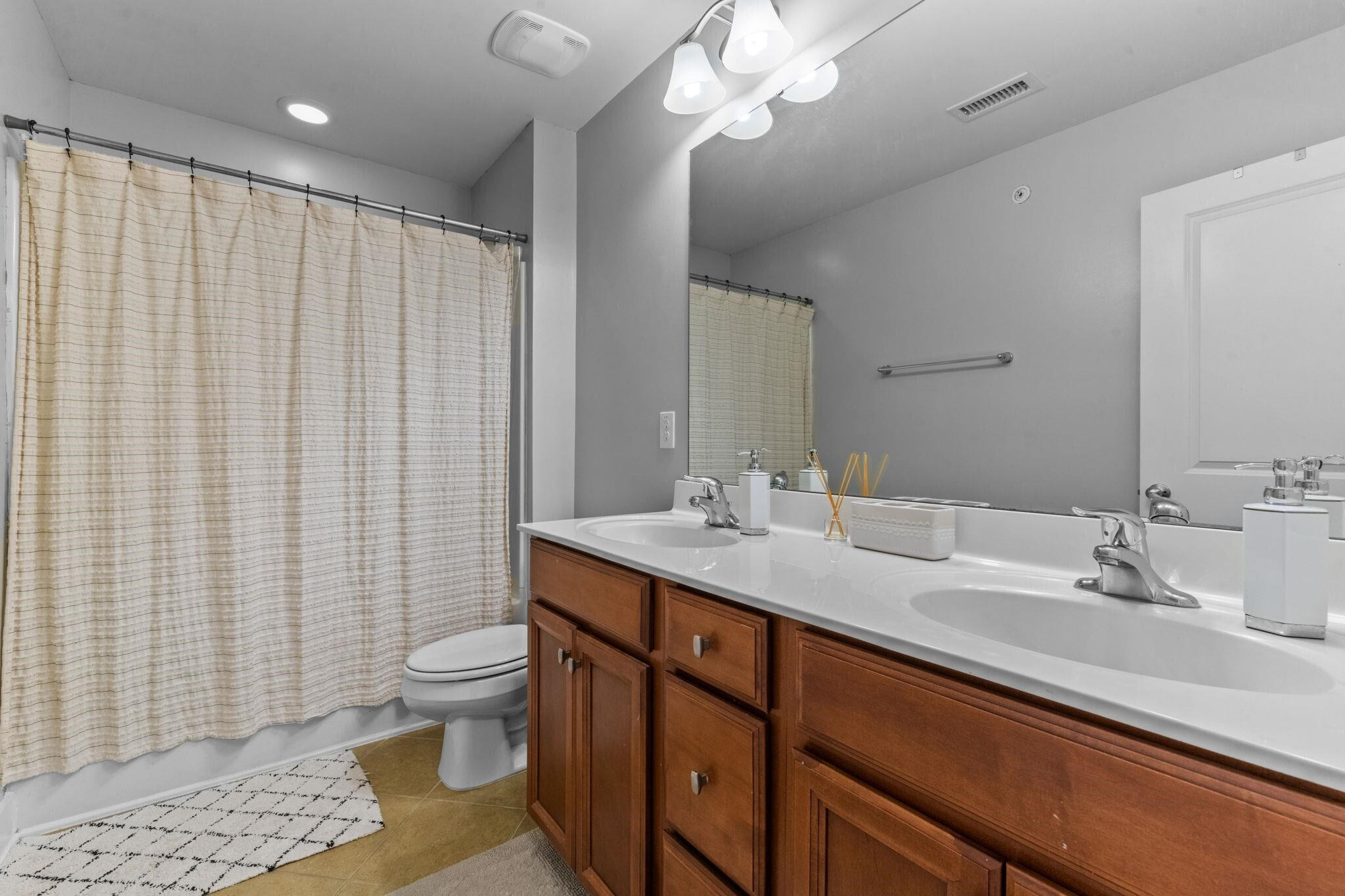 9304 Sevillanos Walk Raleigh, NC 27617 - Photo 36 of 41 a bathroom with a double vanity sink toilet and a mirror