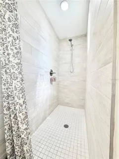 a white bath tub sitting next to a white sink and a shower