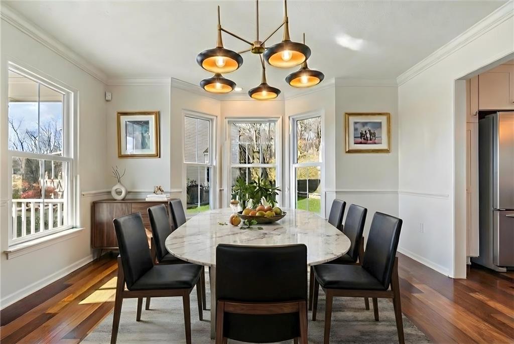 216 Lori Road Gibsonia, PA 15044 - Photo 11 of 50 Virtually staged to inspire the full design potential of this stunning dining room, ideally positioned just off both the kitchen and the grand two-story foyer with adjacent powder room, creating effortless flow for larger gatherings and extended dinner parties.Unlike many homes where dining rooms feel enclosed or tucked away, this space opens beautifully to the soaring foyer, allowing it to function as a true statement feature of the home. The dramatic bay window fills the room with natural light.
