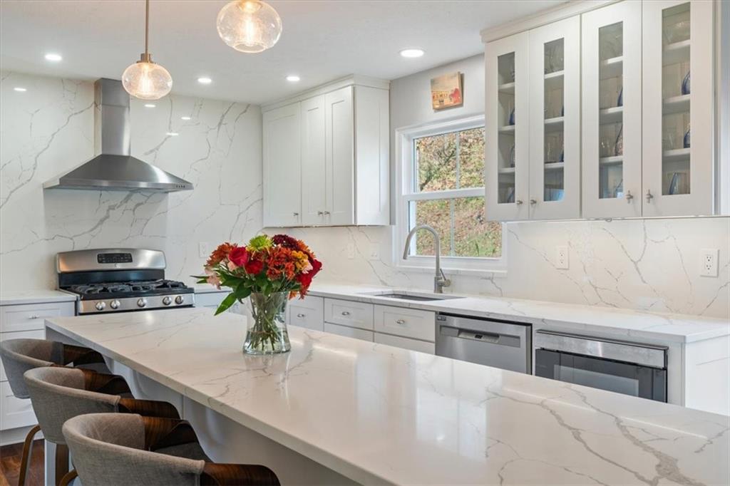 216 Lori Road Gibsonia, PA 15044 - Photo 14 of 50 Fully monochromatic and drenched in Armina Stone Calacatta Lazzo quartz — from the dramatic floor-to-ceiling backsplash feature wall to the sculptural waterfall island anchoring the space.