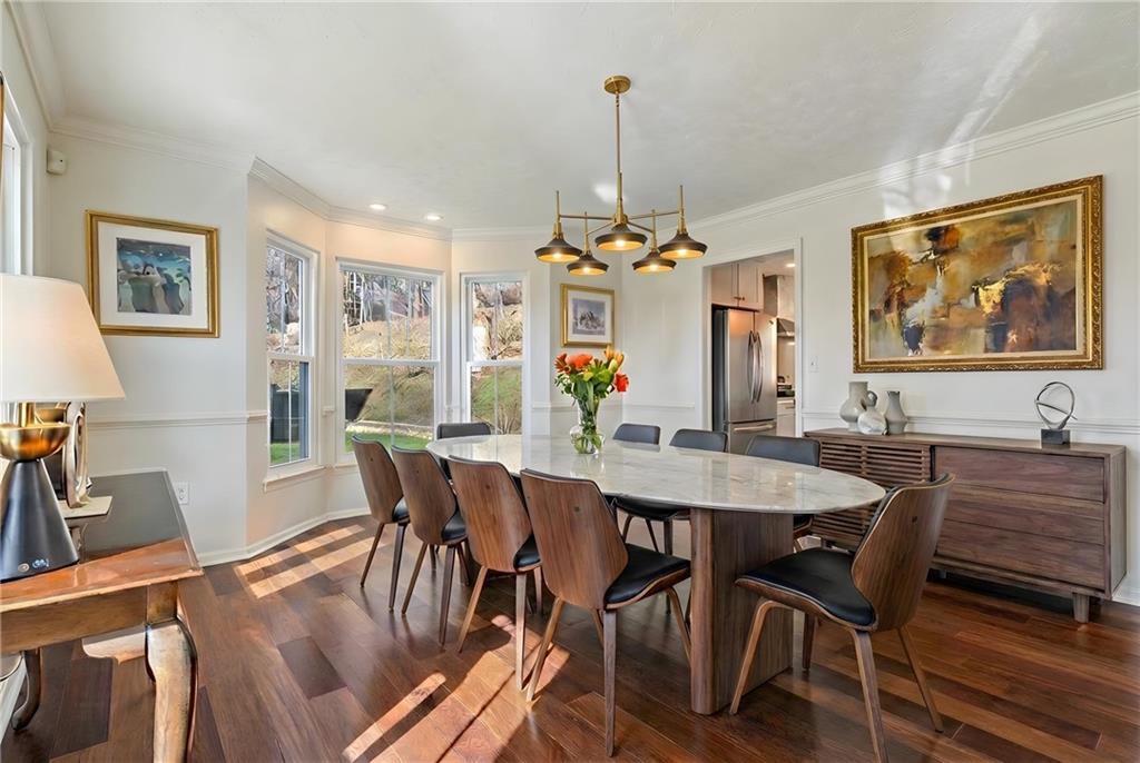 216 Lori Road Gibsonia, PA 15044 - Photo 9 of 50 Virtually staged to inspire the full design potential of this stunning dining room, ideally positioned just off both the kitchen and the grand two-story foyer with adjacent powder room, creating effortless flow for larger gatherings and extended dinner parties.Unlike many homes where dining rooms feel enclosed or tucked away, this space opens beautifully to the soaring foyer, allowing it to function as a true statement feature of the home. The dramatic bay window fills the room with natural light.