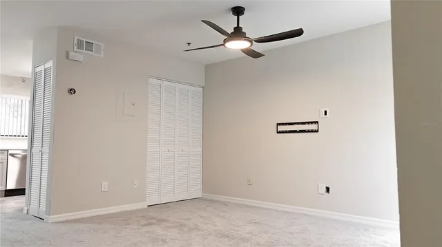 a view of a hallway with a ceiling fan