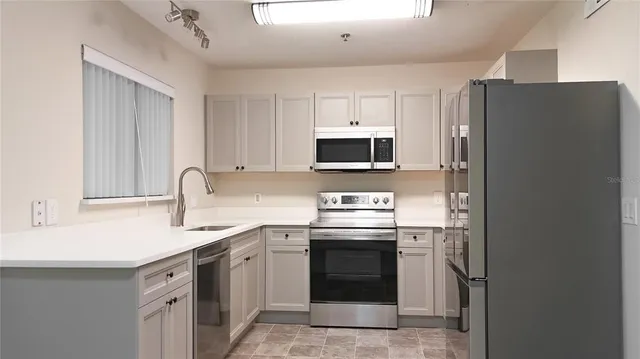 a kitchen with stainless steel appliances granite countertop a refrigerator stove and sink