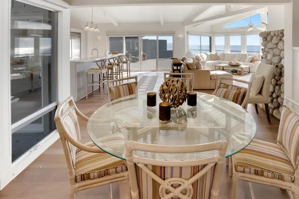 a dining room with furniture a chandelier and wooden floor