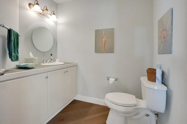 a bathroom with a toilet a sink a mirror and vanity