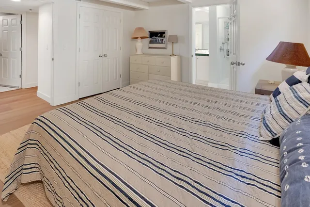 a spacious bedroom with two beds and wooden floor