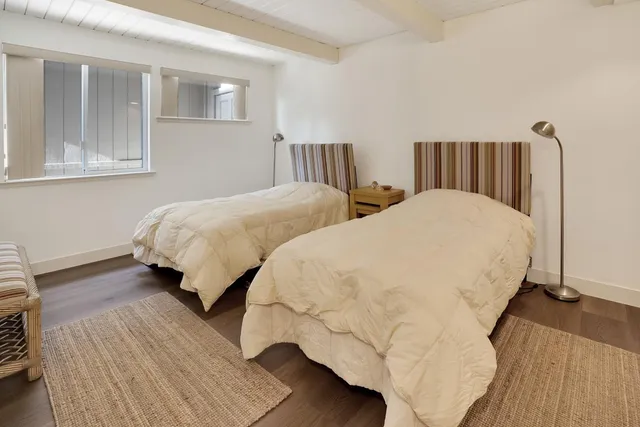 a bedroom with a bed a mirror on the wall and dresser