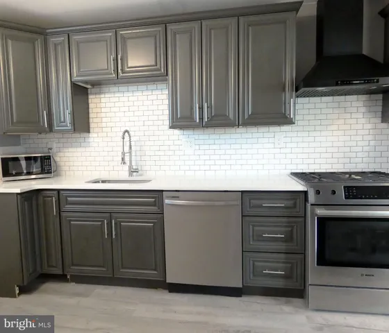 a kitchen with stainless steel appliances granite countertop a sink stove and cabinets
