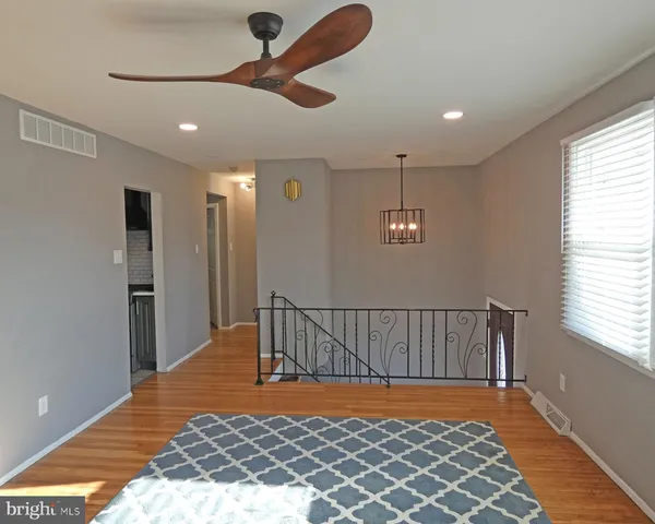 a view of staircase with railing and a chandelier