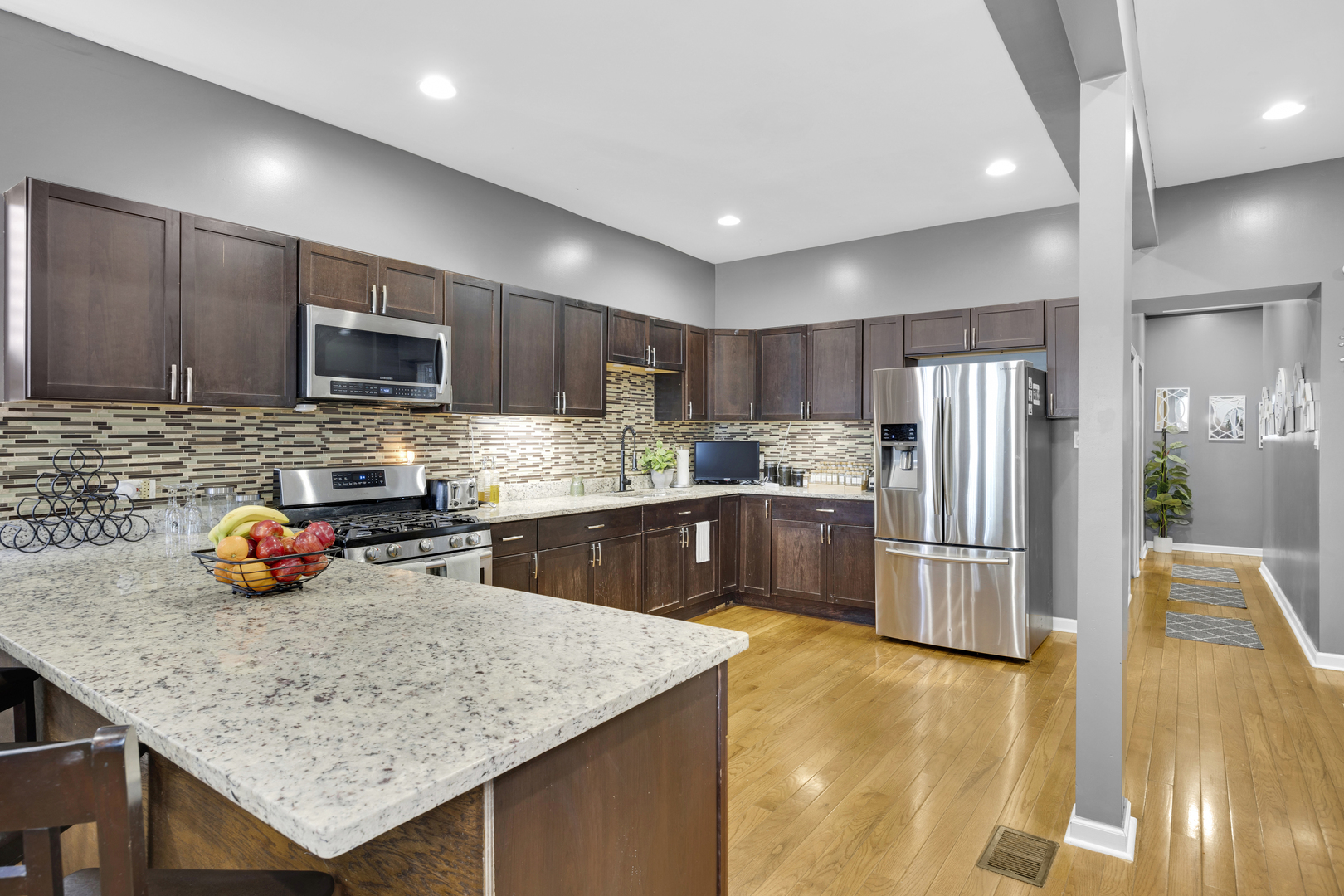 7220 South Carpenter Street Chicago, IL 60621 - Photo 6 of 17 a kitchen with stainless steel appliances granite countertop a refrigerator a sink a stove a microwave and wooden cabinets