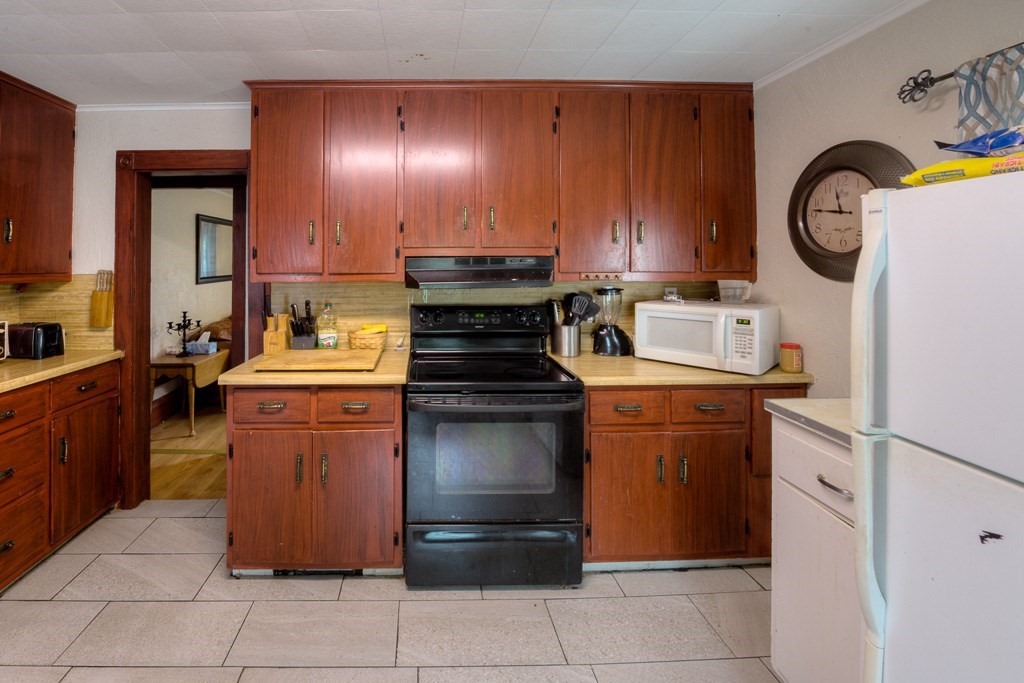 92 Mill Street Lancaster, MA 01523 - Photo 12 of 42 a kitchen with a stove top oven and cabinets