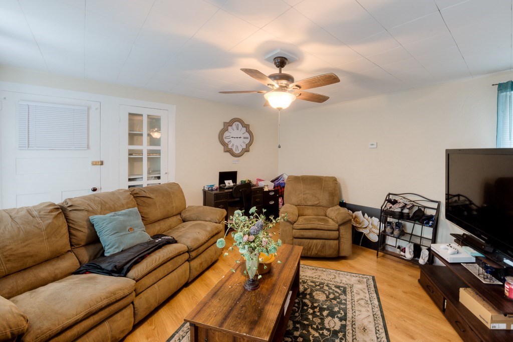 92 Mill Street Lancaster, MA 01523 - Photo 21 of 42 a living room with couches a flat screen tv and a stove with kitchen view