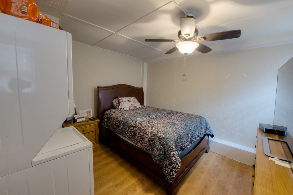 92 Mill Street Lancaster, MA 01523 - Photo 26 of 42 a bedroom with a bed and a chandelier