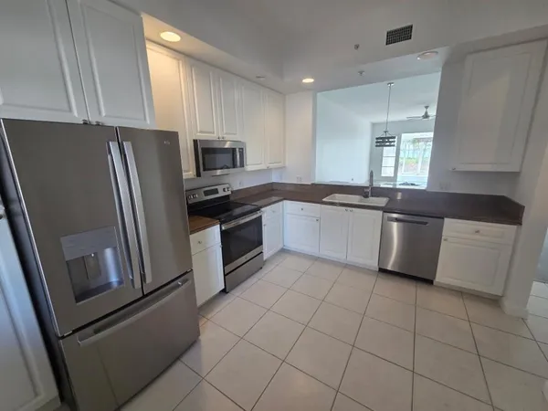a kitchen with stainless steel appliances granite countertop a refrigerator sink and stove