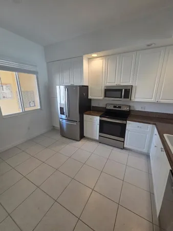 a kitchen with a refrigerator and a stove top oven
