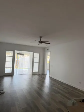 a view of an empty room with window and wooden floor