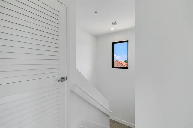 a bedroom with a bed mirror and window