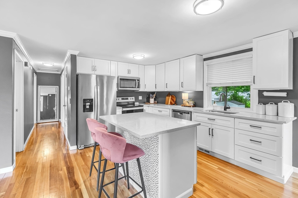 71 Endecott Street Springfield, MA 01118 - Photo 12 of 42 a kitchen with a sink a refrigerator and white cabinets